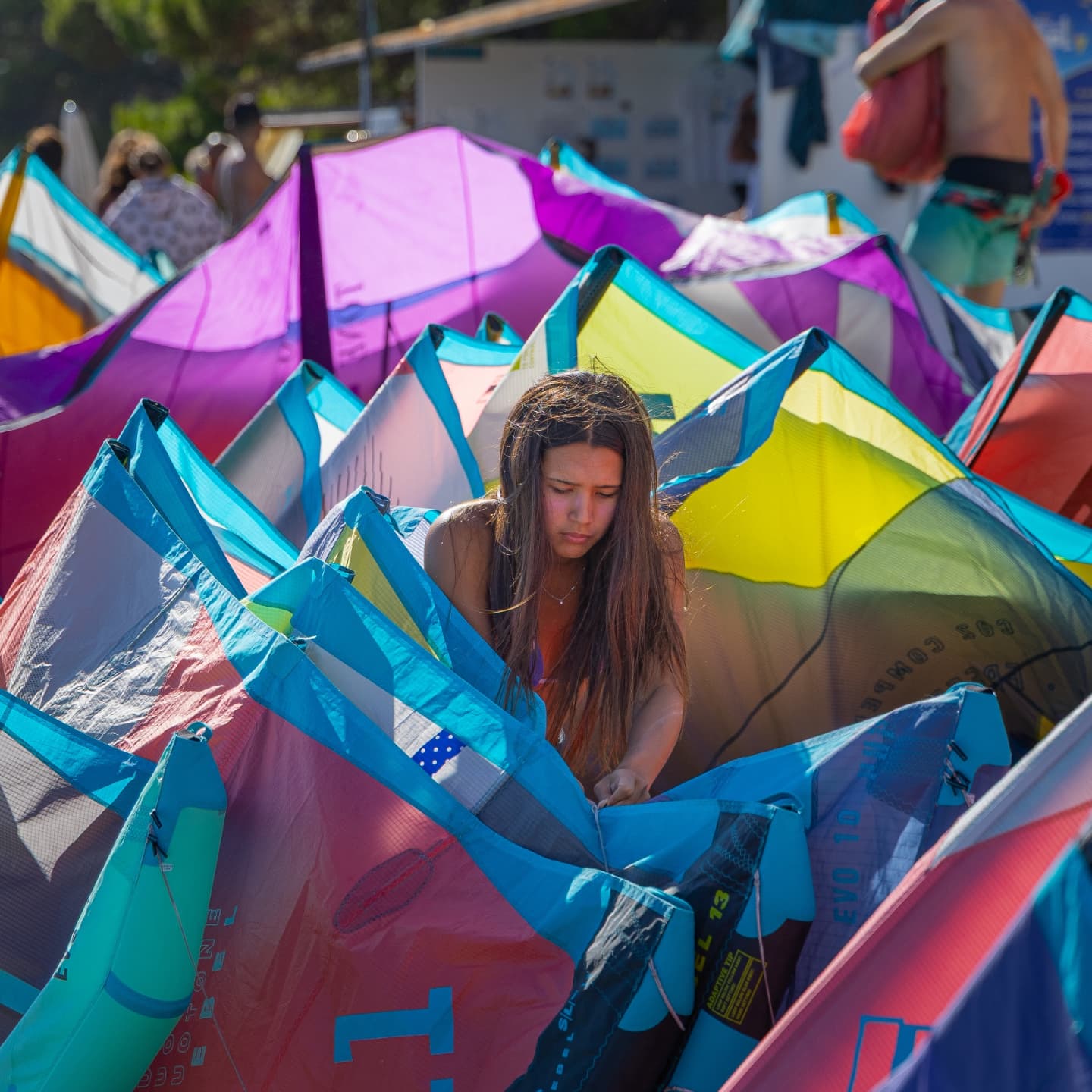 A girl surrounded by colourful kites at Kite School Bol